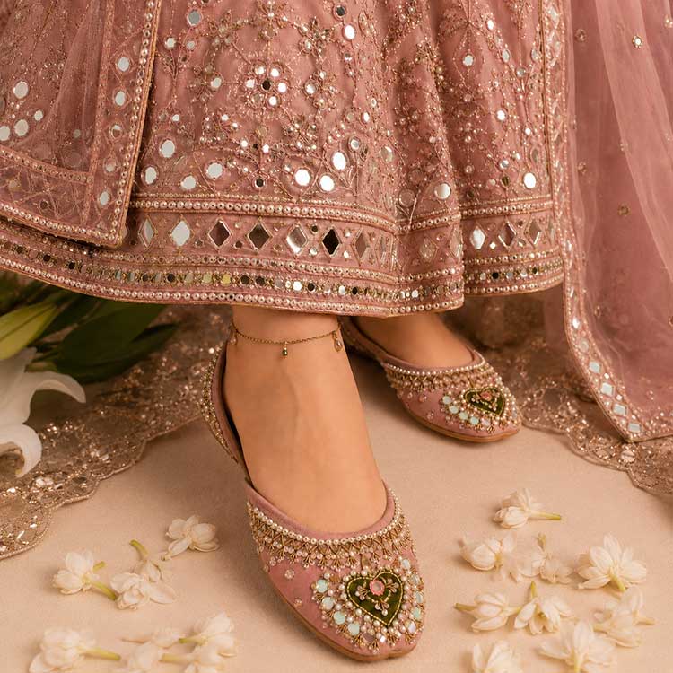Women’s floral print khussa shoes with traditional embroidery, worn with beige pants
